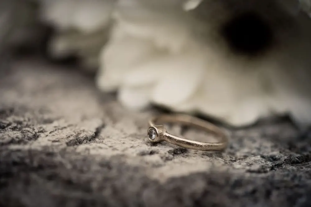 Een smalle ring met één steen op een lichte ondergrond