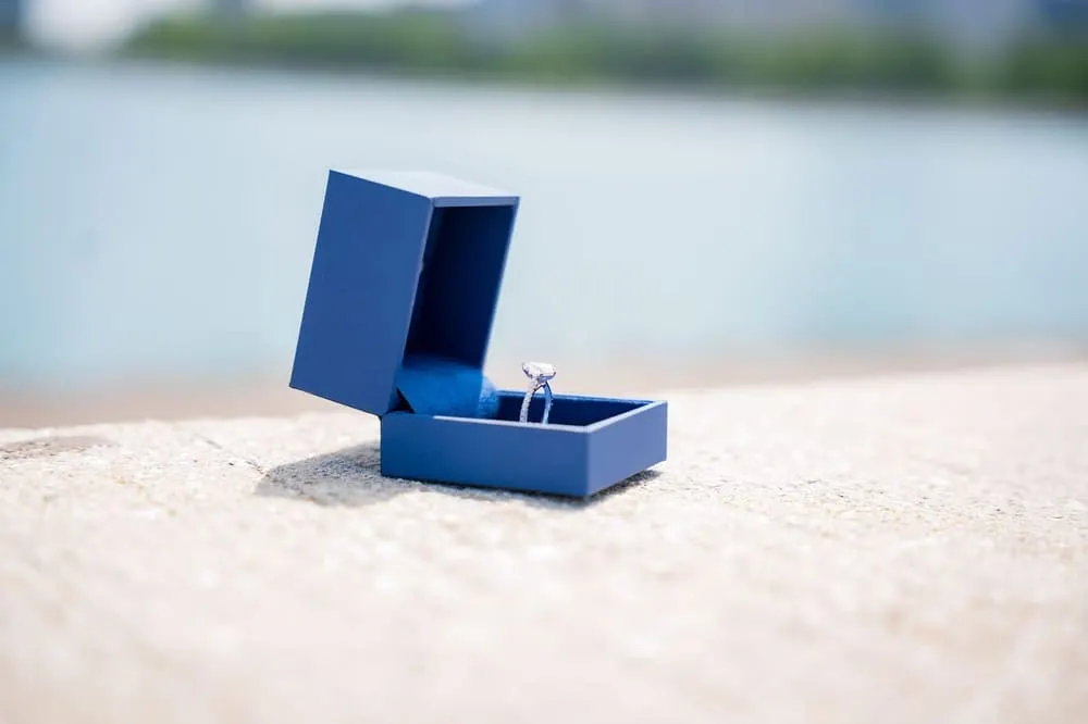 Een ring in een blauw doosje bij het water