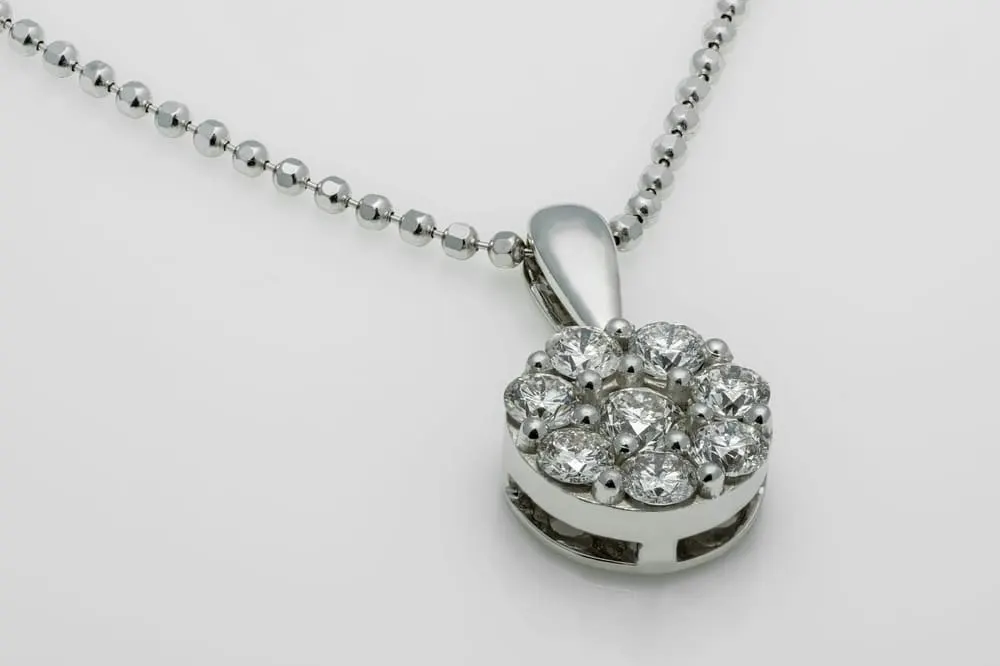 Een hanger met een krans van kleine stenen aan een fijne ketting